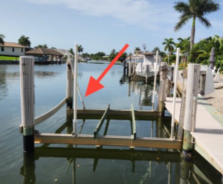 Boat lift cradle and pilings on a Naples canal during an operational test in a home inspection