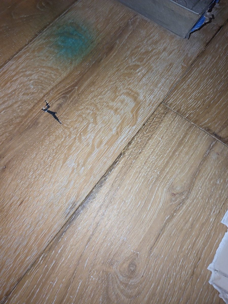Water stain on wood flooring below an air handler closet where the condensate drain line leaked, found during a Naples home inspection