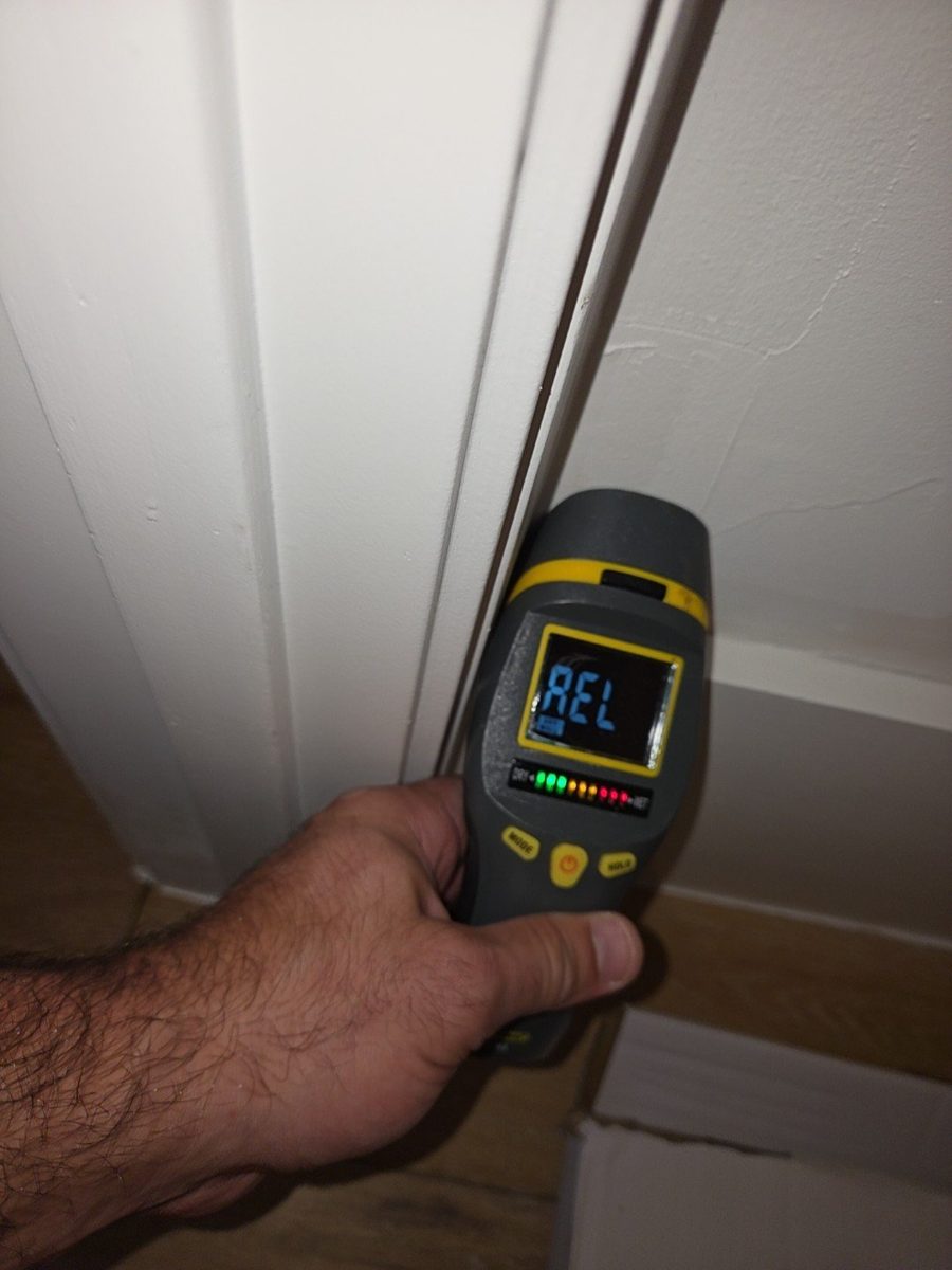 Moisture meter showing elevated moisture on a closet wall next to the air handler during a Naples home inspection