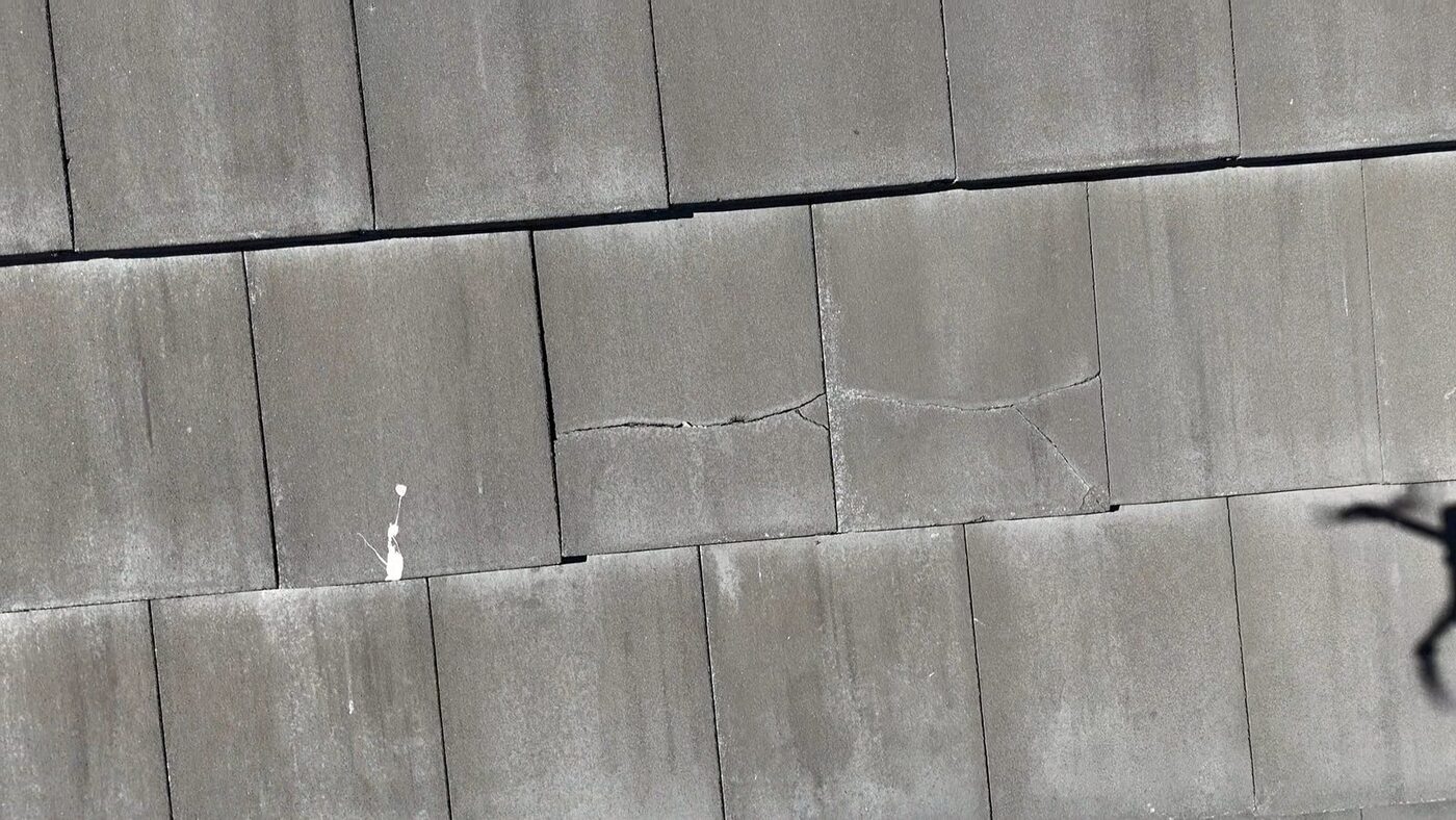 Cracked flat concrete roof tile on a brand-new Naples home
