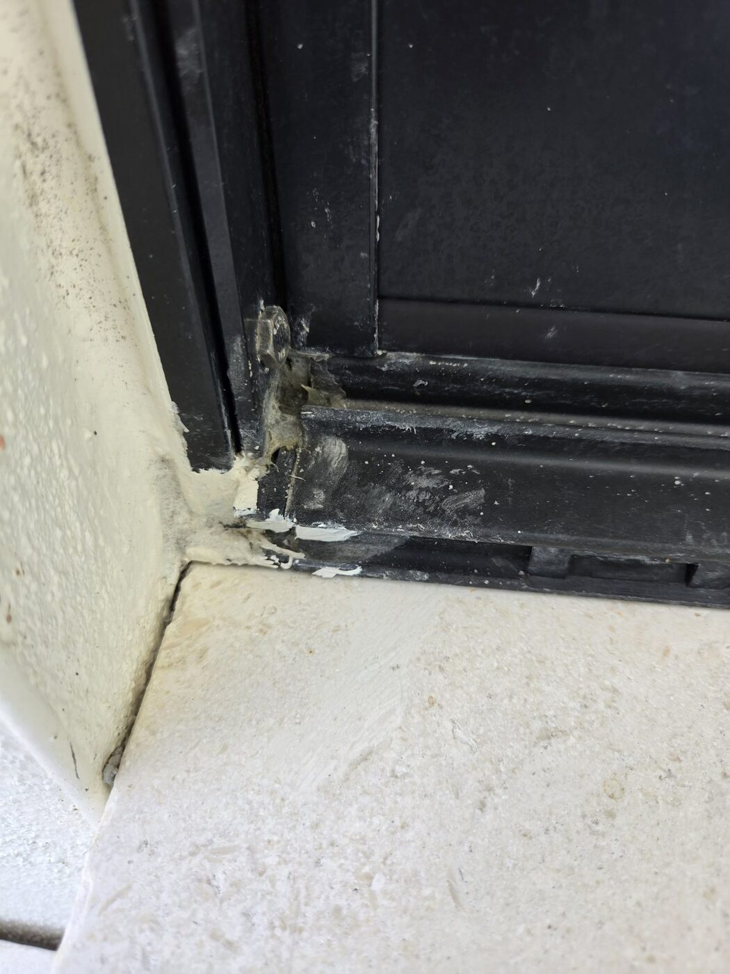 Sealant and paint smears at the corner of a sliding door frame on a new home